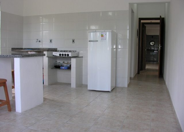 Cozinha, geladeira, fogão e balcão e corredor